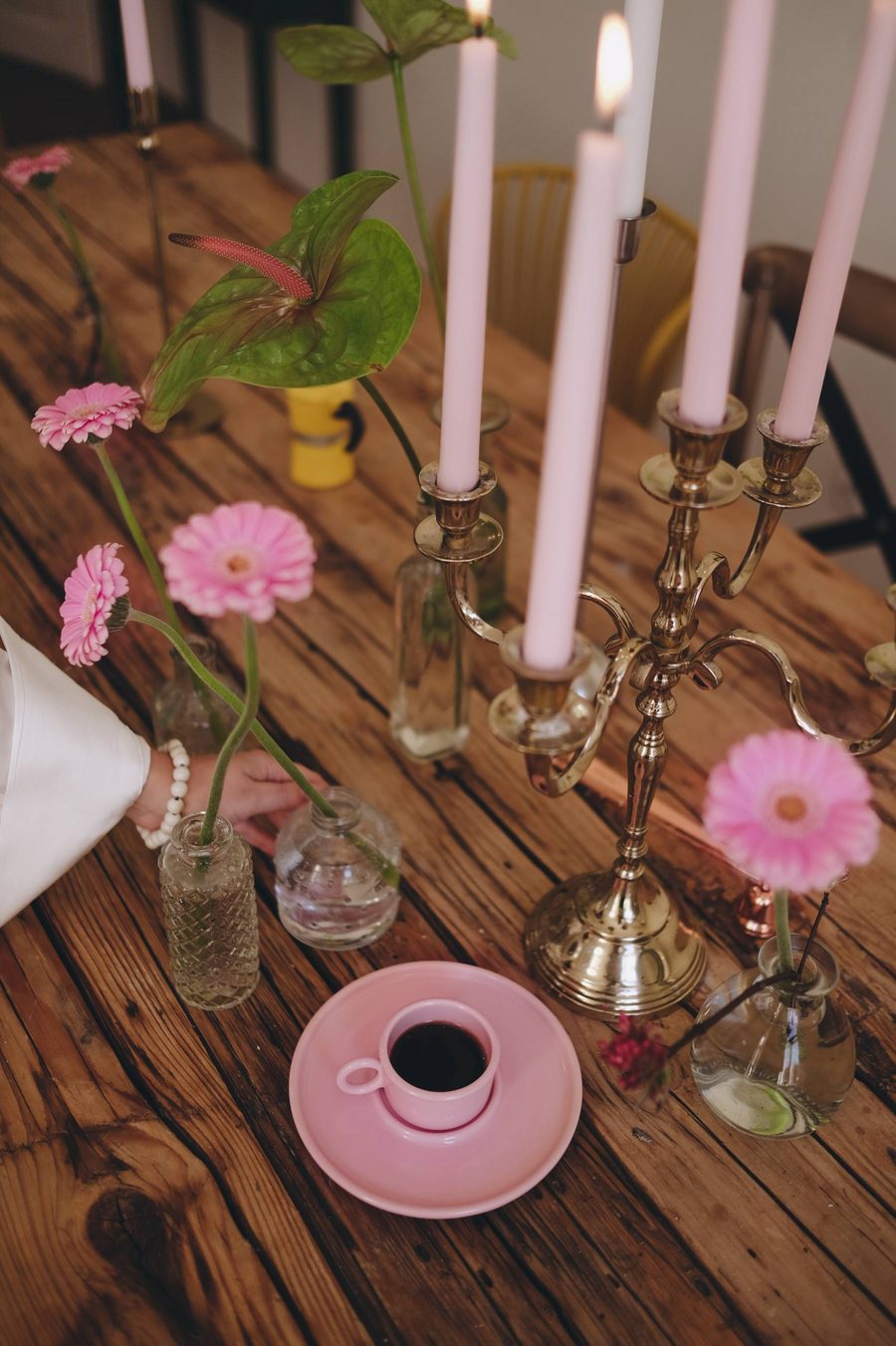 Stół z różowymi kwiatami i świecami w pracowni POSTO